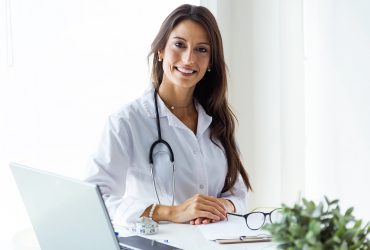 Portrait of beautiful young female doctor looking at camera in the office.